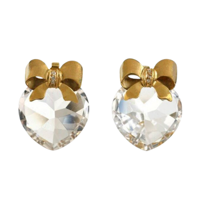 Gold bow-shaped earrings with clear heart-shaped gemstones on a white background